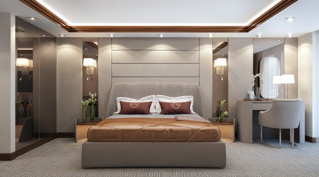 jpgThis picture shows a modern luxury bedroom with elegant decor. The room features a grand king size bed that is upholstered in light grey velvet, and the bedding is layered with neutral colors and texture. A dark grey chaise lounge is situated in the corner of the room, and an accent chair upholstered in a light patterned fabric sits next to it. The walls are painted white, and the hardwood floor is covered with a plush area rug. On the wall over the bed is an ornate gold framed mirror, and built-in dressers and clos