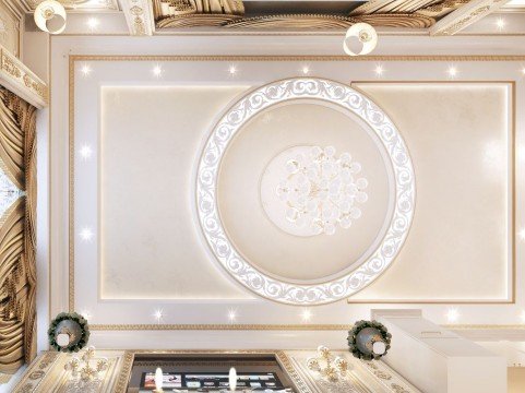 This picture shows a luxurious and modern living room with marble flooring. The room has contemporary furniture, including two white couches, an ottoman, and coffee table. There is a large TV mounted on the wall and a crystal chandelier hanging from the ceiling. The walls are adorned with beige and cream wallpaper combined with gold accents. Behind the couches is a built-in shelves filled with books and art pieces, making this room a cozy and comfortable place to spend time.