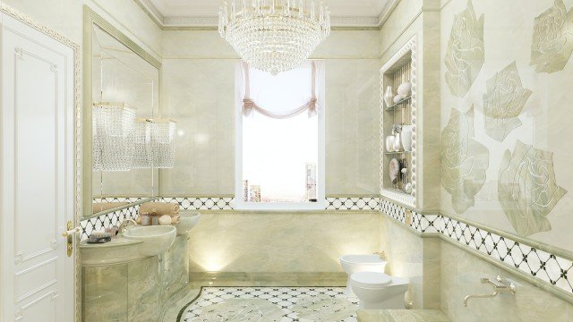 This picture shows a luxurious interior design featuring beige walls and a white ceiling, an ornate gold chandelier, and two cream-colored couches in the center of the room. There is a gold frame mirror and two tan armchairs facing each other on either side of the couches. The floor is a wood-paneled parquet that has a dark brown border around the edges. A large round black coffee table is placed in the middle of the couches. In addition, there are abstract paintings on the wall as well as a large white rug underneath the furniture.