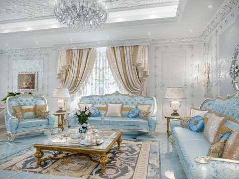 This picture shows a modern and luxurious living room. It has a white marble floor, pale colored walls, an elegant crystal chandelier, and a long beige couch with accent pillows. There is also a rectangular coffee table in the middle of the room with a large glass vase filled with artificial flowers. To add a touch of color to the room, there are two blue armchairs near the couch. The room also features two stately chairs near the window, perfect for conversation or relaxation.