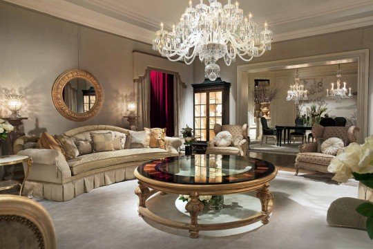 Modern living room featuring a stylish brown sofa, crystal chandelier, and wall-mounted TV framed with custom wallpaper.