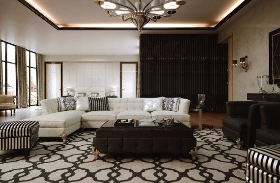 This picture shows an ornately decorated bedroom with a sophisticated and contemporary design. The walls are painted in a neutral, beige color, while the furniture is mostly white with gold accents. The bed appears to be large and is flanked by two nightstands. The headboard is decorated with a variety of shapes and patterns, and the accent pillows add a bright touch of color to the space. There is also a large mirror and a luxurious chandelier that adds an extra element of glamour.