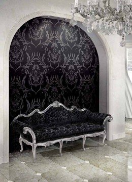 This picture shows an elegant Mediterranean-style foyer with a luxurious marble floor and ornate iron railing. The walls are decorated with golden accents, while the ceiling is designed with decorative wooden accents and a large crystal chandelier. A beautiful patterned rug and a large vase of flowers add a touch of color to the classic design.