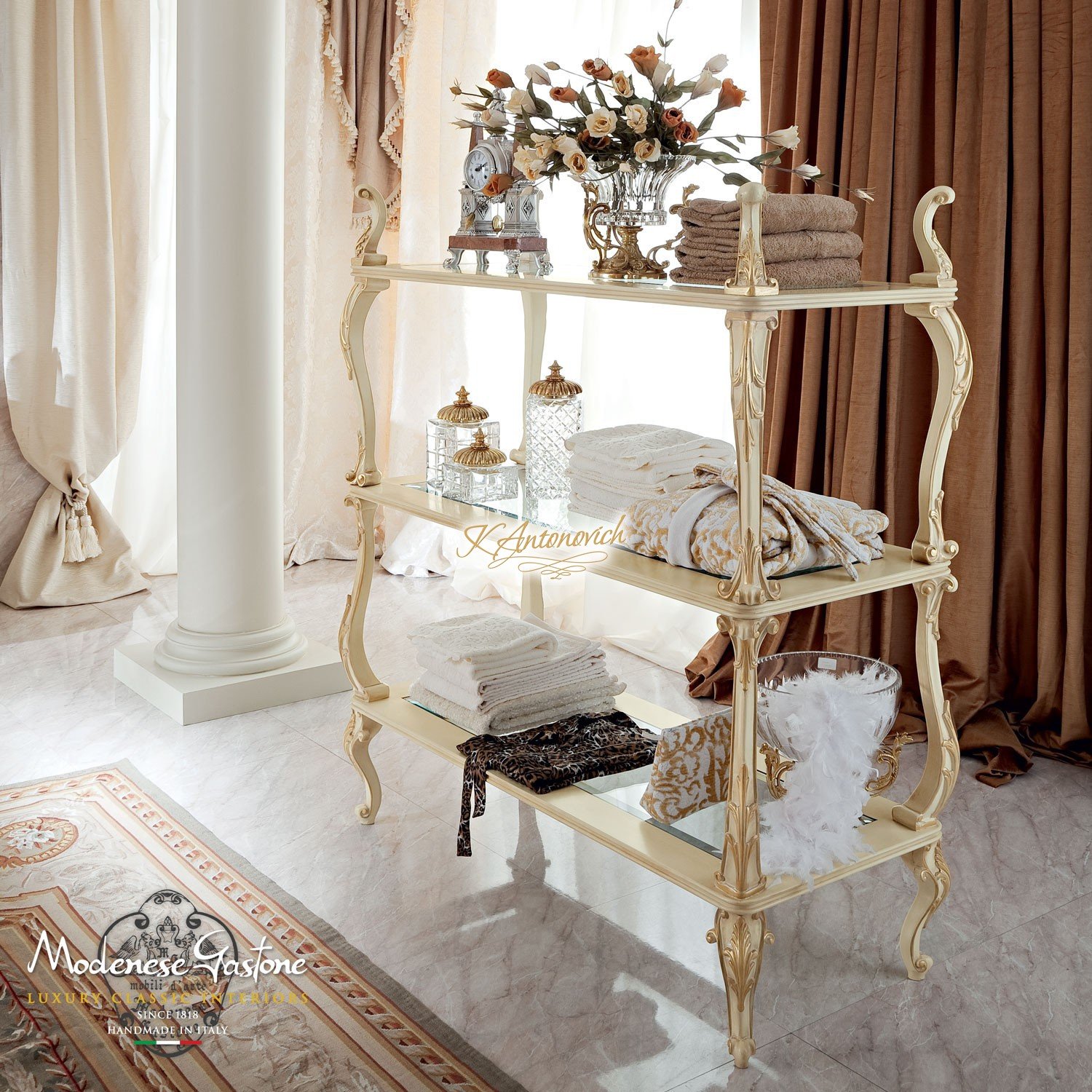 This picture shows a modern bedroom designed in the Art Deco style. The room boasts a sleek and luxurious interior, featuring a ceiling adorned with a gold-painted dome and ornate lamp fixture, ivory walls, and a glimmering chandelier. The furniture has elegant curved lines which give the room a sophisticated feel, and a white and gold rug completes the look. The bed is upholstered in velvet, adding an extra touch of softness and luxury.