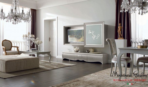 This picture shows a luxurious and modern living room design. The room features light beige walls with an elegant patterned wallpaper accent wall. There is a white marble flooring and a large cream-colored rug that add a warm and inviting touch to the space. The furniture is made up of several ivory-colored sofas and matching armchairs, along with a couple of wooden coffee tables and side tables, all with intricate details. The room also has several eye-catching fixtures, including a black and chrome chandelier, sleek sconces and modern wall lamps, as well as
