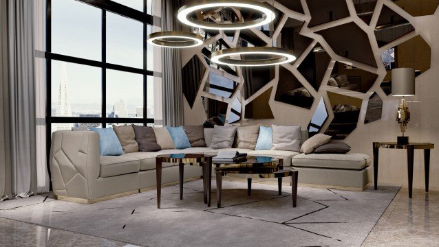 This picture shows an elaborate living room in a luxury home. The walls are painted in a white hue, and the floor is covered in a white and gray patterned rug. The furniture includes two luxurious white leather sofas, two brown leather armchairs, and a glass and chrome center table. The wall behind the sofas has a built-in bookshelf with glossy white cabinets. On the opposite side of the room, there is a large window with sheer white curtains and a large crystal chandelier hanging from the ceiling.