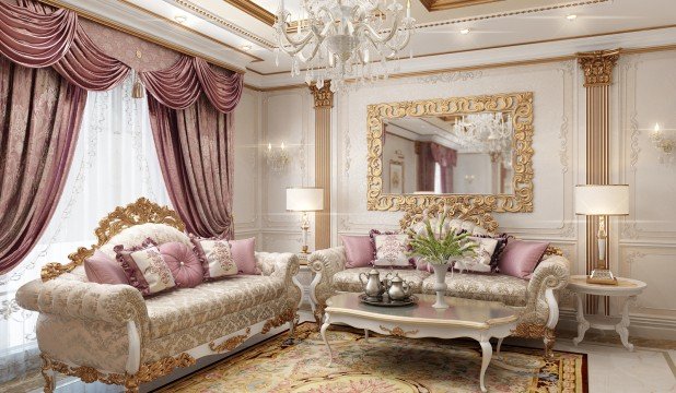 This picture shows a luxurious bedroom featuring a grand four-poster bed with ornate gold accents. The bed is accompanied by two nightstands with matching gold accents and crystal lamps. The room also has a plush white rug, a crystal chandelier, and drapes in cream and white. A large wall mirror with an ornate gold frame hangs above the bed completing the regal look of the room.