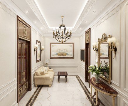 This picture shows a luxurious living room with modern and contemporary design elements. The room features an ornate white marble fireplace, a soft beige sofa, two ivory armchairs, and a glass-top coffee table. There is also an intricate patterned rug beneath the furniture and crystal chandelier suspended from the ceiling. On each side of the fireplace are large windows, letting in ample natural light. The walls are painted a pale shade of grey and decorated with a few black and white prints.