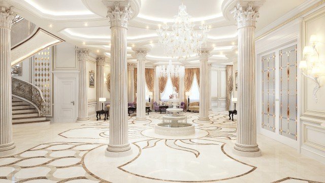 This picture shows an ornate room with white walls, a wooden floor, and luxurious gold and silver accents. In the center of the room is a grand gold-accented sofa and armchair set. The cushions are a deep blue velvet and have intricate designs on them. On either side of the sofa are elegant side tables adorned with sculptures and large lamps with intricate patterned shades. To the left is a wall filled with shelves and drawers, while to the right is a large window overlooking a lush garden.