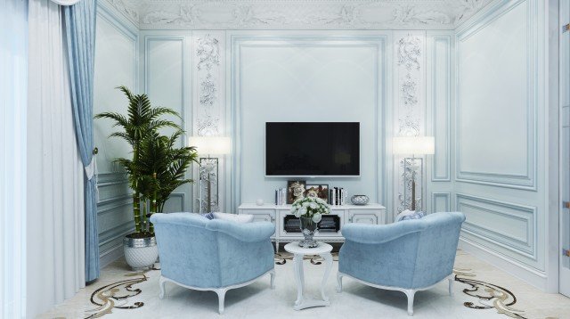 This picture shows a modern, luxurious living room with an off-white colored couch facing two matching armchairs. In between the two armchairs is an ornate wooden coffee table with a black marble top. There is a tall, white bookshelf with glass doors against the wall behind the couch, and atop it sits various decorative accessories, such as a framed painting and a vase. To the right of the couch is a semi-circular floor lamp with a white shade. On either side of the couch are rectangular glass side tables with metal legs. The walls and floors of the