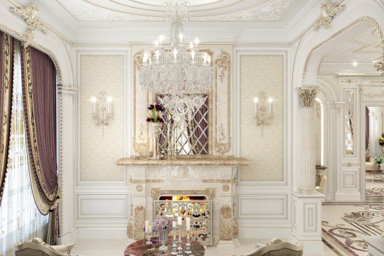 This picture shows a luxurious dining space with a custom marble table, a contemporary crystal chandelier, and an exquisitely decorated wall. The space is decorated in shades of off-white, beige, and gold. There is a cream-colored, tufted leather bench at one side of the table, while the other side features two white leather chairs. Ambient lighting is strategically placed throughout, creating a warm and inviting atmosphere.