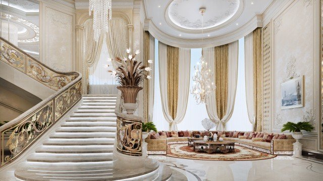 This picture shows an elevated view of a modern living space. The room is open plan, with a sofa and chairs grouped around a large coffee table in the center. The walls are painted a soft beige color, with white trim accents and modern light fixtures. A staircase leads up to an upper level, and there is a wood floor with various-sized area rugs throughout. The room has plenty of windows, providing ample natural light.