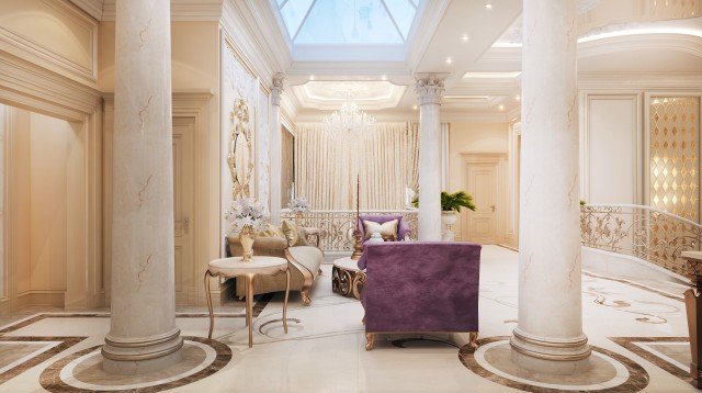 This picture shows a spacious and elegant living room with a classic design. The room features white walls and high ceilings with large windows allowing lots of natural light. In the center of the room is a cushioned sofa upholstered in a patterned beige fabric, facing a large antique fireplace encased in white marble. On either end of the sofa are two matching armchairs covered in a similar fabric. A large wooden coffee table sits between the sofa and chairs. Along the walls of the room are large mirrors and two glass-front bookcases filled with books. Above the fireplace hangs