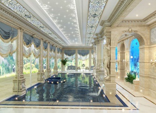 The picture shows an elegant upscale bathroom design. The walls are a light beige or sand color, and there is a shower encased in white tiling with a mosaic accent wall. In the corner lies a claw-foot tub, with a set of small steps leading to a higher level. The vanity area has his and her sinks, and there is a large mirror with gold trim. A chandelier, a few sconces, and a few plants complete the luxurious look.