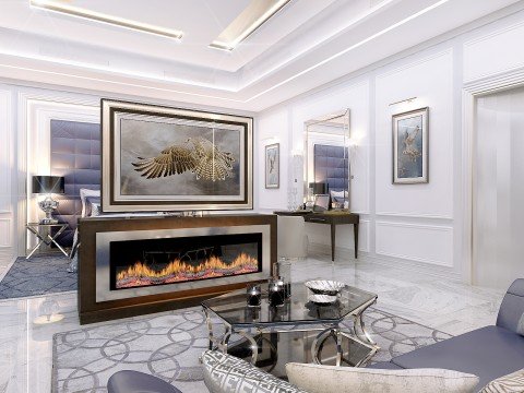 This picture is showing the interior of an elegant, modern living room. The room has a large white sofa against one wall, with two blue armchairs on either side. A low, wooden coffee table sits in the center of the room, between the two pieces of furniture. The walls are painted a light gray and feature art pieces hanging in two symmetrical arrangements. Several tall potted plants have been placed throughout the space, adding a touch of greenery to the overall design.