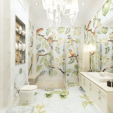 This picture shows a large bathroom with ornate marble floors, walls, and fixtures. The walls are adorned with white, gold, and silver accents, giving off an opulent feel. In the center of the room is a large sunken bathtub surrounded by a white rail, with two steps leading up to it. On either side of the tub is a long countertop with a single sink and golden fixtures. A large mirror hangs above the sink and reflects the luxurious surroundings, while two tall windows bring in natural light.