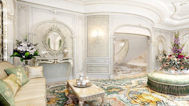 This picture shows a luxurious foyer with a grand, marble staircase. The walls and ceiling are exquisitely decorated with glass chandeliers, intricate molding, and ornate gold accents, creating a lavish atmosphere. The stairs feature two marble statues on either side, as well as two additional statues at the foot of the stairs. A large painting is hung above the stairs, drawing attention to the room's grandiosity.