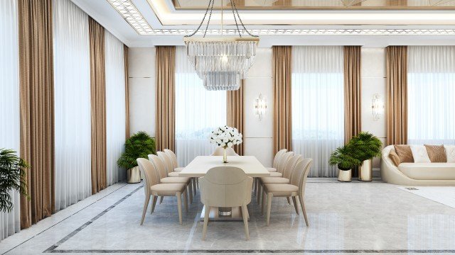 This picture shows an elegant, modern living room. It has a golden-brown color scheme, with beige and ivory accents. The room features a luxurious chaise lounge chair and ottoman, a sleek coffee table, tall bookcases, and an elaborate rug on the floor. In the background, you can see a large window with sheer curtains and a beautiful landscape outside.