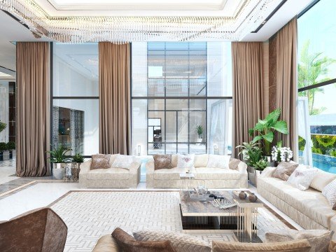 This picture shows an elegant, contemporary living room design. The space has a light beige/gray color palette and is furnished with neutral-toned modern furnishings. The walls are lined with framed art pieces and illuminated by sconces. In the center of the room is a luxurious white marble-top coffee table with an ornate gold-plated base surrounded by four white armchairs. The room also features patterned area rugs and a stylish fireplace mantel decorated with vases.