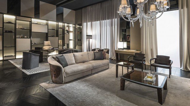 Interior of modern living area with huge windows, stone fireplace and gray furniture that create a warm and cozy atmosphere.