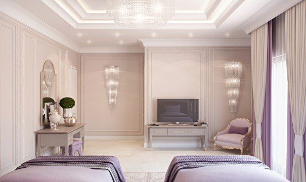 This picture shows a modern and luxurious dining room. The room features an elegant glass table with gold legs, surrounded by six white leather chairs with gold trim. The walls are adorned with golden accessories, and there is a large crystal chandelier hanging from the ceiling. The floor is a neutral beige color and has a patterned rug underneath the glass table.