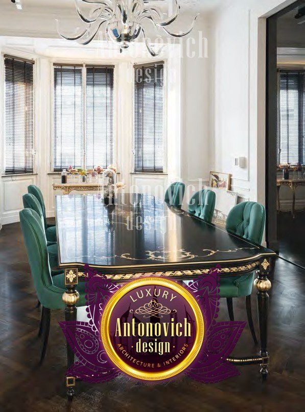 The picture shows an opulent kitchen with gold and black details. The kitchen features dark cabinetry with a glossy finish, marble countertops, and a large island with a breakfast bar. There are also two recessed lighting panels above the island and a modern pendant light hanging from the ceiling. The kitchen also has gold accents in the form of a decorative backsplash and handles on the cabinets.