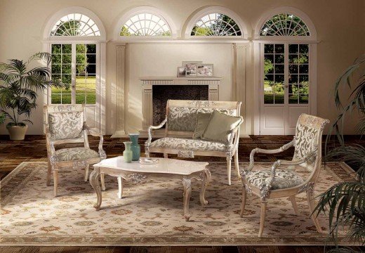 This picture shows an elegant entryway to a modern home. The walls are painted in a beige color and the floor is a luxurious white marble. The entrance way is illuminated by two framed round sconce lights, and two glass panel doors provide access to the rest of the house. A luxurious jute rug with a patterned border rests on the marble flooring, and a wall-mounted console table with gold decorative details stands against the left wall.