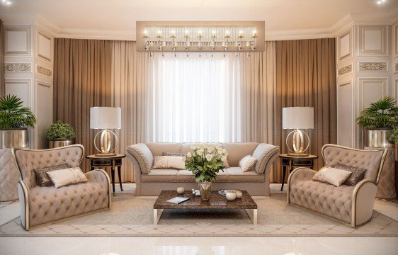 This picture shows a modern interior design of what appears to be a luxurious living space. It has sleek white walls, an elegant white chandelier, and a black and gold mirrored accent feature along the back wall. There are several comfortable white chairs arranged in a semi-circle around a coffee table, and a large beige sofa positioned against the back wall. A round gold center table sits in the middle of the chairs with two small black end tables to either side.