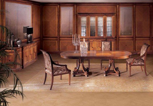 This picture shows an ornately decorated dining room with a large round black table in the center. The walls are painted with a glossy white finish, while the floor is surfaced with a luxurious white and grey marble tile. The table is surrounded by elegant black chairs with a tufted velvet upholstery. The room is further accented with crystal chandeliers, exquisite artwork, and several statement pieces of furniture in gold and silver tones.