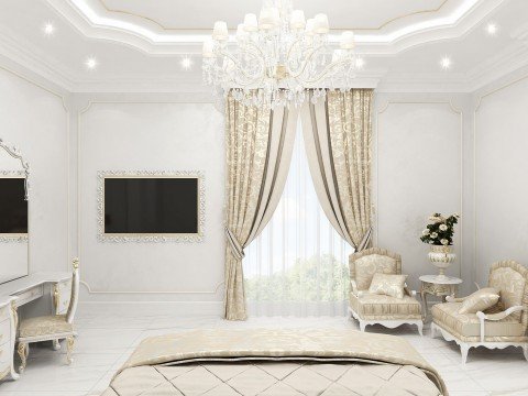 This picture shows a modern, luxurious living room. The room has white and gold walls, with grand windows to allow natural light to enter the space. The room is furnished with a contemporary light grey sofa and ottoman, a glass coffee table, and two beige armchairs. The walls have stylish wall art, a white fireplace and chandelier, and decorative accents such as vases and a potted plant. On the floor is an intricate rug, and the whole look is completed with a bold black and white patterned area rug.