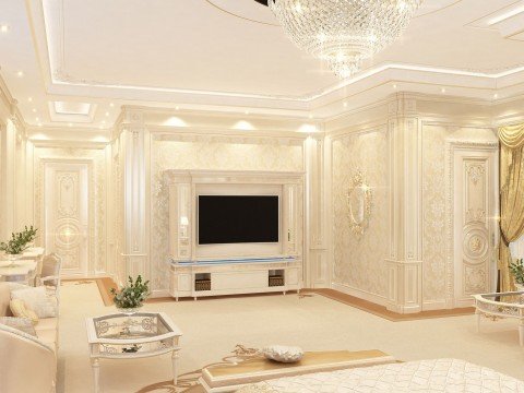 This picture shows a luxurious modern living room with a high ceiling. The room is decorated with beautiful golden ornaments and accents, and the walls are painted a pale grey color. There is a white marble fireplace in the corner and a large mirror above it. The furniture consists of an off-white sofa, armchairs, and coffee tables, which are accented by floral decor and a soft white rug.