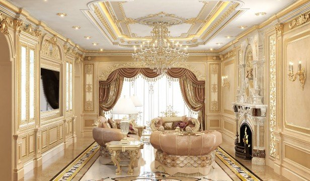 This picture shows a luxurious white and gold bedroom interior decorated with elegant furniture and accessories. The room includes a king-size four poster bed draped with white and gold curtains, two velvet armchairs, and a grand mirror surrounded by ornate white and gold moldings. There are also two end tables with matching lamps on either side of the bed, and several decorative pieces such as a cluster of gold framed art prints and candle holders. The overall look is one of luxury and sophistication.