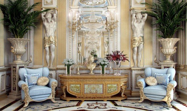 This picture shows a classic, opulent living room. The walls are covered with classic textured wallpaper, and the floor has a beautiful cream marble flooring. There is an intricately detailed fireplace, adorned with a large painting hung above it. The walls on either side of the fireplace are filled with tall bookshelves, containing various decorations and art pieces. There is an ornate gold chandelier setting off the luxurious vibe, and two white sofas arranged in a conversational seating area in the center of the room. Several artwork pieces and silk rugs complete the classic look