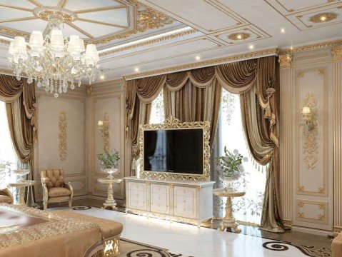 This picture depicts an opulent living room with luxurious furnishings and décor. The room features a two-seater sofa upholstered in velvet, two matching armchairs, a marble-topped coffee table, and a large ornate mirror mounted on the wall. The floor is made of dark hardwood and is covered by a large patterned rug. Above the furniture is a grand crystal light fixture. The walls are painted a deep burgundy and decorated with gold detailing.