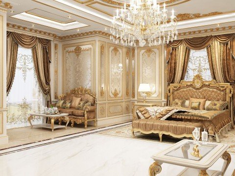 This picture shows a luxurious bedroom in a modern home. It features a white bed with a unique headboard, along with white and gray pillows. There is a stylish side table with a round lamp on top, and a comfortable armchair with a gold metallic frame. The walls are painted in a soft pastel shade, and the room is illuminated by an elegant crystal chandelier. On the wall behind the bed is a large abstract painting with a mix of blues and grays.
