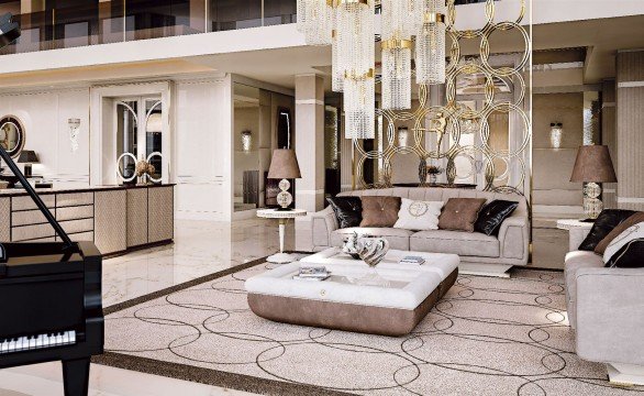 This picture shows a luxurious residential room. It has elegantly designed furniture and decoration, including gold accents and chandeliers. The walls are painted in neutral tones and the floor is covered with luxurious white carpeting. The room also includes two sofas upholstered with velvet fabric and accented with brass legs, two cozy armchairs, and a marble accent table with a tall golden vase on top.