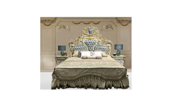 This picture shows a luxurious bedroom designed by Antonovich Design. The room features several pieces of elegant furniture and decor, including a brown leather bed frame with matching night stands, a crystal chandelier suspended from the ceiling, beige curtains framing the wide windows, and a patterned area rug on the floor. The walls are decorated with an ornate wallpaper featuring cream and gold accents.