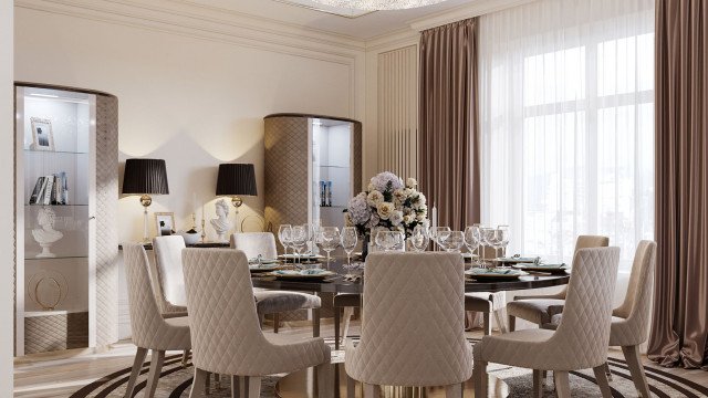 This picture shows an elegant modern living room, featuring a large L-shaped white sofa with light gray patterned pillows, a glass and chrome coffee table, gray armchair, and brown pouf. The white walls are decorated with framed images, and the room is illuminated by stylish lamps set atop side tables. A bright pink rug adds a pop of color and texture to the space.