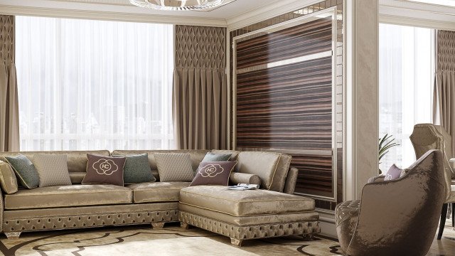 This picture shows a living room designed with luxury elements. The walls and ceiling are decorated with ornate wood paneling, and the floor is covered in a luxurious carpet. A white chaise lounge chair sits in front of the marble-faced fireplace with an intricate mantle. On either side of the chair are two white armchairs. The center of the room is lit by a large, crystal chandelier providing ambient lighting. The walls are painted in warm, neutral colors and adorned with elegant paintings.