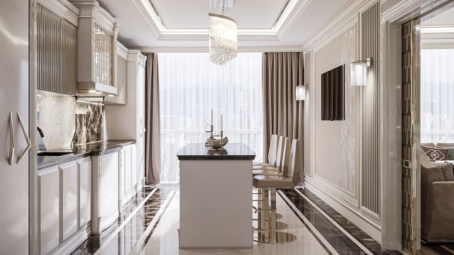 This picture shows a luxurious living room in a modern style. It features cream-colored walls, white crown moulding, and dark hardwood flooring. There is a large comfy sectional sofa in light beige fabric upholstery, with two matching armchairs. The furniture is paired with a chic round glass coffee table and a mid-century inspired end table. An exquisite crystal chandelier hangs from the ceiling, illuminating the room.