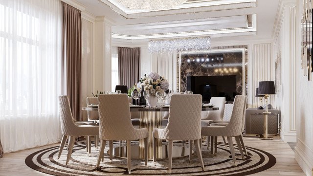 This picture shows a grand, luxurious living room with dark wood flooring and rich, velvet upholstered furniture. The walls are covered in a light gray damask wallpaper. The room is also decorated with gold framed paintings and a marble fire place. An elegant crystal chandelier hangs from the ceiling above a large, round coffee table.