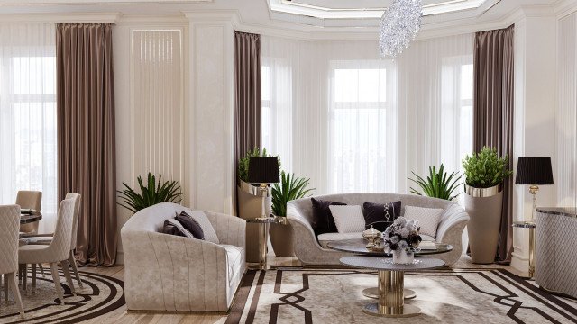 This picture is of a grand and luxurious living room designed by the luxury interior design firm Antonovich Design. The room features tall and ornately decorated white walls with large, stately windows. In the center of the room is a grandiose crystal chandelier that hangs from the high ceiling. The floor is done in a beige marble pattern with a white rug in the center. There is plush beige furniture arranged around the rug, including an L-shaped couch, armchairs and a coffee table. The furniture is accented with gold trim and decorative pillows. On either