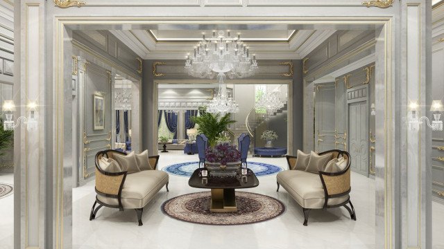 This picture shows a modern, luxurious living room designed by Antonovich Design. The room has several dark-colored sofas and armchairs arranged in a conversational setting, as well as a low coffee table with a glass top. The walls are adorned with modern artwork as well as a large mirror and crystal chandelier for a touch of elegance. The floors are a light wooden finish, and the ceiling is lit up with recessed spotlights.