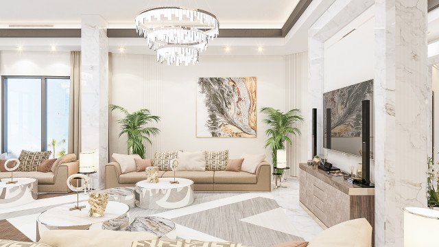 This picture shows an exquisite living room designed with a sleek and modern aesthetic. The walls are predominantly white, and the floor is covered in an intricate light grey and white rug. The furniture has a simple, minimalist design and is upholstered in lush velvet fabrics in shades of navy and gold. An elegant round glass chandelier hangs from the ceiling and provides a sense of opulence to the room.