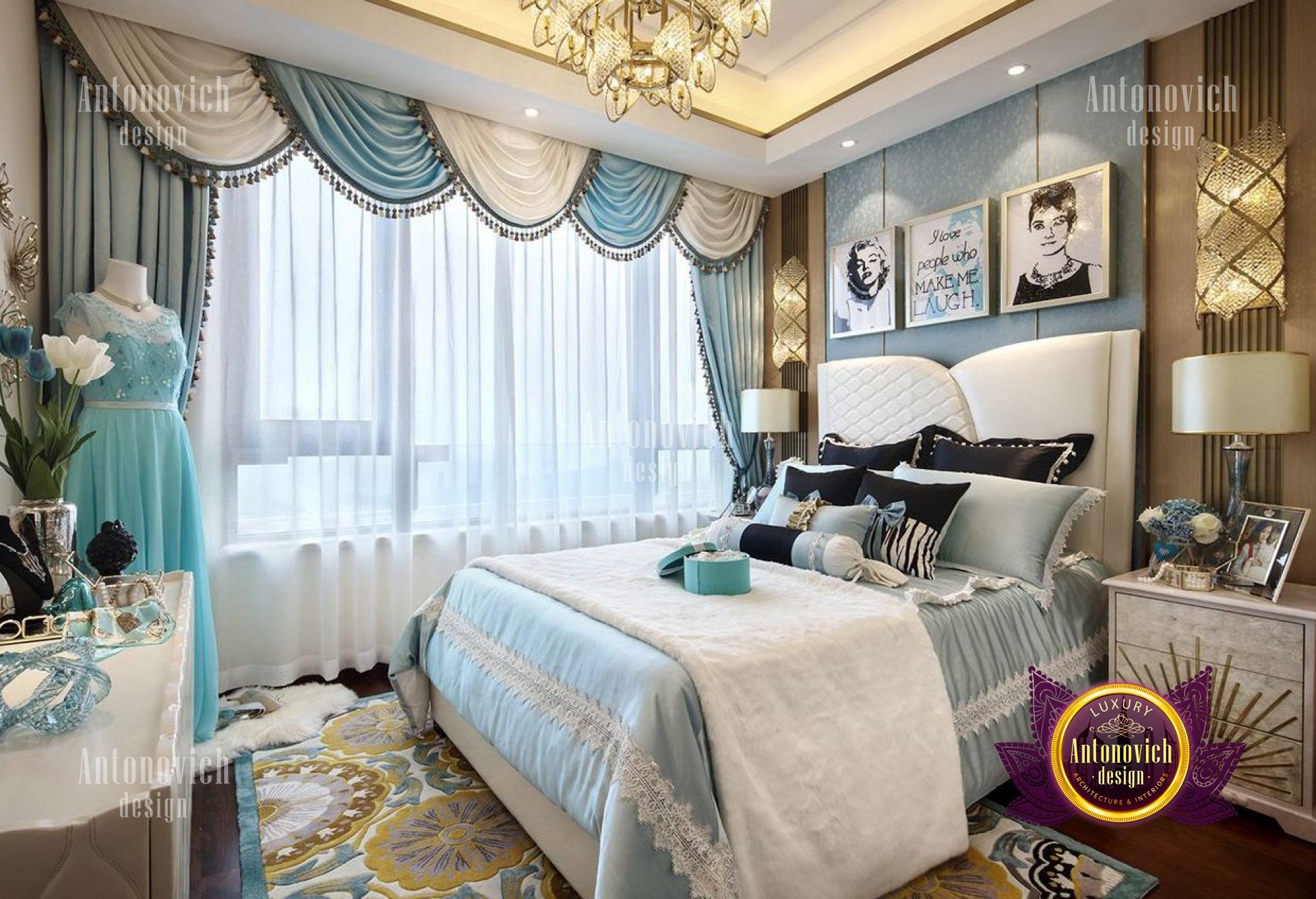 This picture shows a large and luxurious bedroom. It features a black and white color scheme and a predominantly modern design. The walls are painted in a light gray and adorned with decorative sconces and framed artwork. The bed is covered in luxurious fabric with high-end bedding, while the area around it is carpeted in light beige. A large window allows natural light to flood the room and brings a sense of openness to the space. The room is finished off with a mirrored dresser and a curved chair.