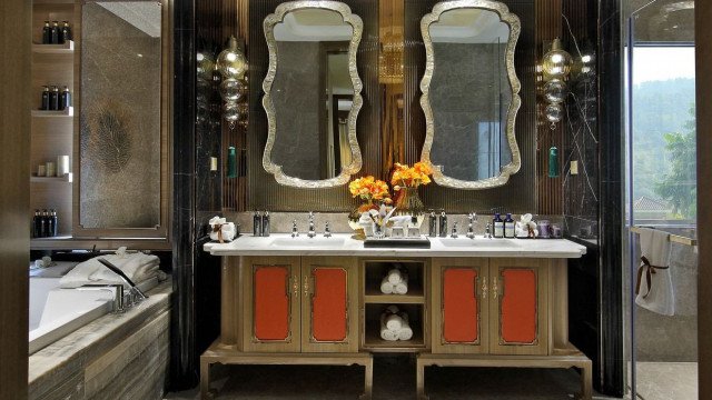 A luxurious dining room featuring a custom-made, royal blue velvet couch with an ornate, gold-plated table and chairs.