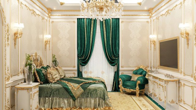 This picture shows an ornate and luxurious bedroom interior. The walls are painted in a warm beige color, with white accents along the baseboards and door frames. The room is furnished with two large bronze canopy beds, each with a white duvet and pillows, and luxurious, patterned drapery surrounding them. An intricately carved headboard spans one wall, and matching nightstands flank each bed. On the left side of the room, a cozy seating area consists of two white chairs facing a round ottoman, with a marble-top table in between. A