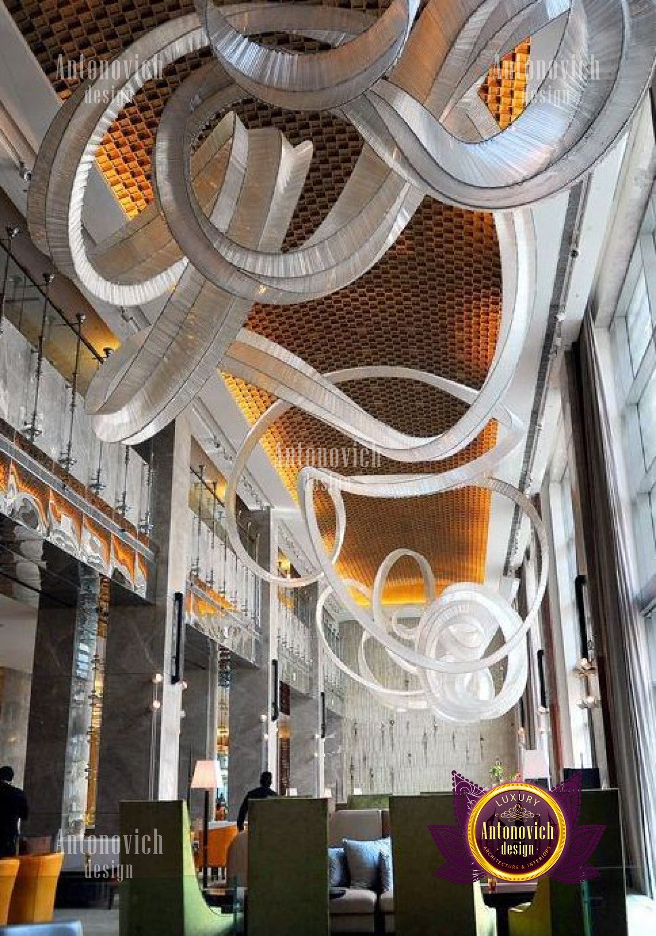 Spiral staircase featuring wooden railings and marble steps leading to a grand foyer.