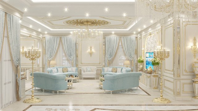 This picture shows a modern and luxurious living room. The room features an ivory sectional couch with an eggshell tufted pattern and matching chair with four gold-plated legs. Other features include a glass coffee table with a white top, a beige rug, and a crystal chandelier. The walls are painted in a warm shade of cream and have an art deco-inspired design and accent lighting.