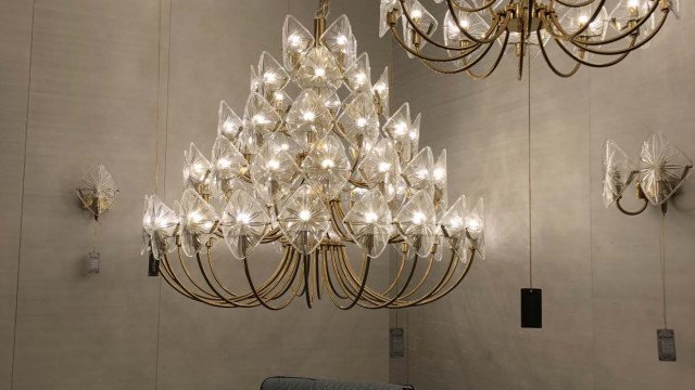 Interior design of a modern drawing room featuring a yellow sectional sofa, a white coffee table, and a pendant lamp.